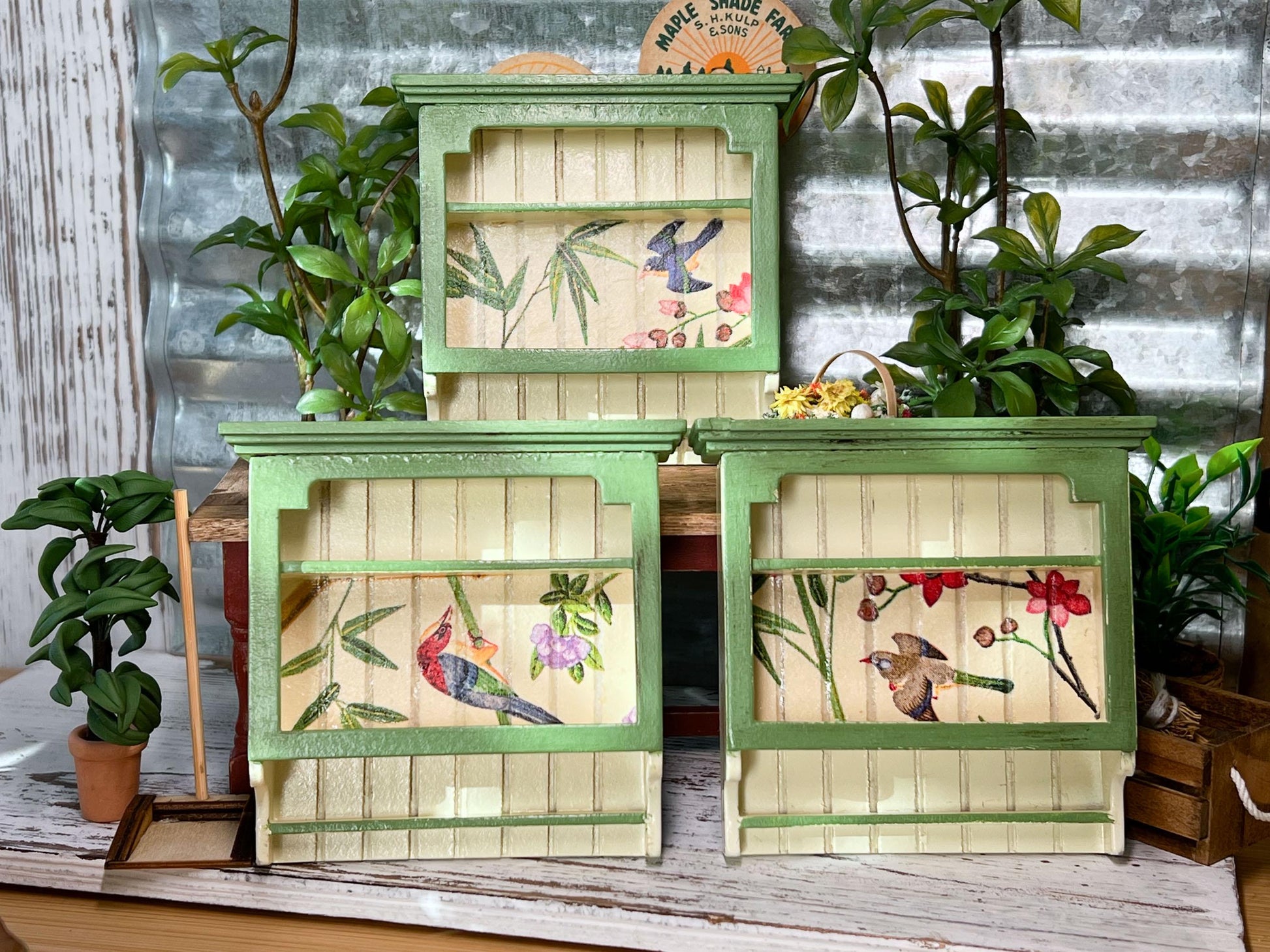 This adorable 1:12 scale wooden wall-hanging shelf features a light-yellow finish with a soft green top, creating a beautiful two-tone look that complements any miniature kitchen decor. The decoupage paper detail enhances its country-style charm. __etsy:6681355651