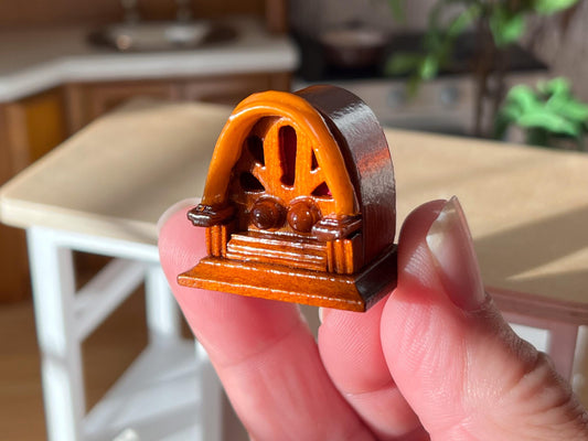 Dollhouse miniature vintage wooden radio, it is a cutie in every way; it has two non-working knobs, a curb oval body design with a carved front and red background, and it sits on a raised pedestal. __etsy:6378738418